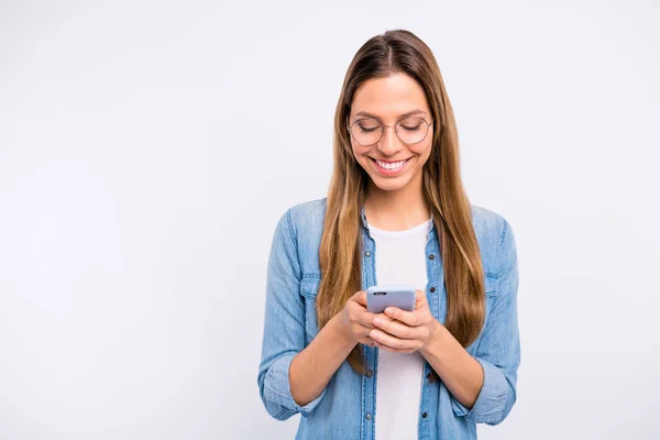 Фото очаровательной привлекательной приятной дамы с сияющей улыбкой, держащей в руках новый телефон на изолированном сером фоне — стоковое фото