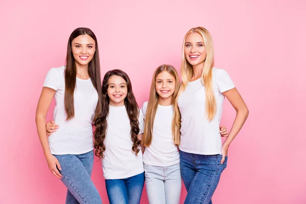 Foto de quatro diferentes idade senhoras abraçando desgaste casual roupa isolado fundo rosa — Fotografia de Stock