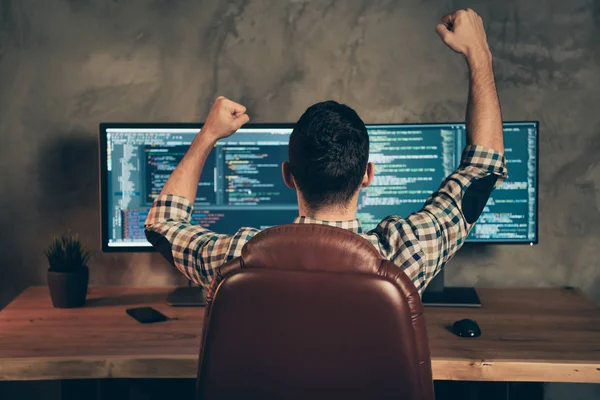 Achterzijde Achteraanzicht van Brunet Guy dragen gecontroleerd shirt professionele expert zittend in de voorkant van het scherm vieren prestaties bij houten industriële interieur werkplaats station — Stockfoto