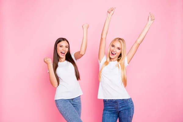 Foto de dos damas alegres por el logro fresco desgaste traje casual aislado fondo rosa — Foto de Stock