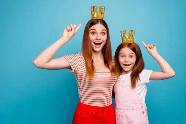 Emocionado foxy pequena senhora e mamãe indicando dedos na tiara usar roupa casual isolado fundo azul — Fotografia de Stock