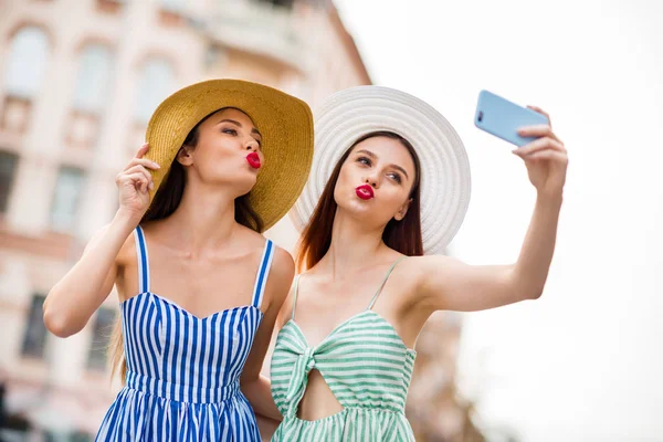 Retrato de pessoas bonitos estudantes com lábios amuados pau cabelo morena fazendo foto enviando beijos de ar vestindo vestido na cidade — Fotografia de Stock