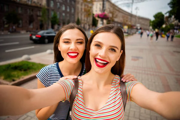 Крупный план фото веселых дам с красными губами палкой делая фото в полосатой футболке в городе на открытом воздухе — стоковое фото