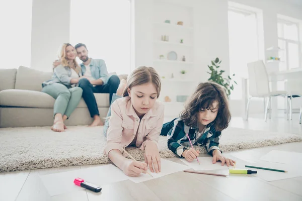 Zdjęcie z Big Family dwoje dzieci leżącej podłodze puszyste dywan tworzenia rysunków, podczas gdy rodzice cieszyć oglądania przyjazne adoptowane dzieci — Zdjęcie stockowe
