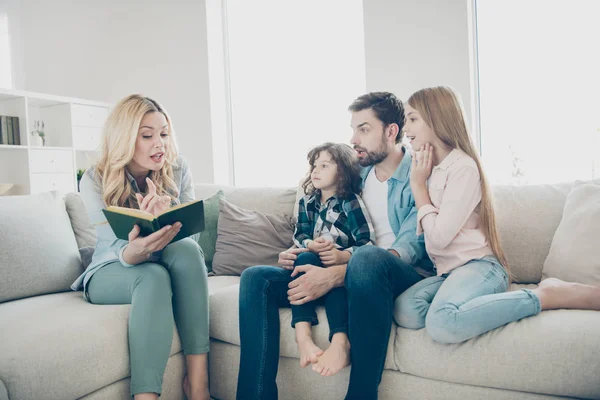 Joven familia grande dos niños cómodo sofá sentado escuchar mamá lectura emocionante cuento de hadas — Foto de Stock