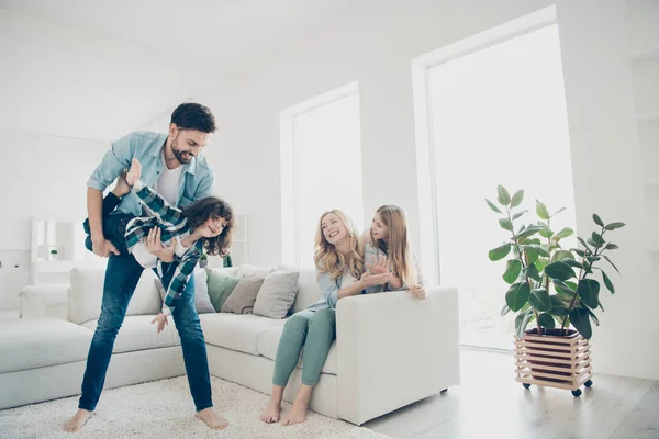 Foto de cuatro personas adoptan familia moviéndose como avión con ayuda de los padres manos acogedores apartamentos en el interior —  Fotos de Stock