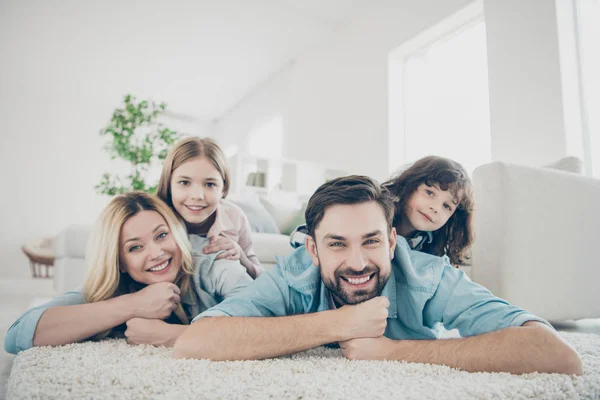 Foto de quatro membros adotados família deitado chão dentes sorridente tapete macio aconchegante apartamentos — Fotografia de Stock