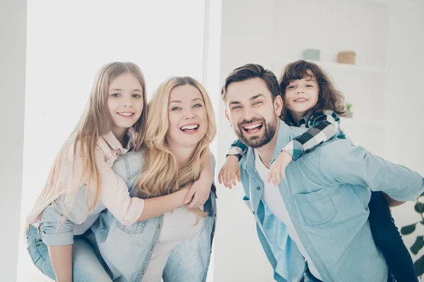 Photo of big family four members hugging carry little children piggy back indoors apartments — Stock Photo, Image