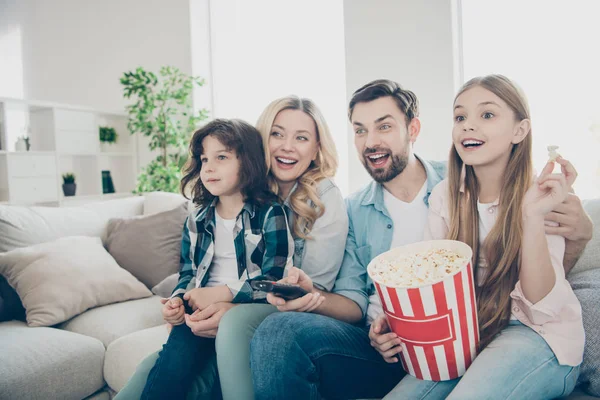 Photo of big family four members spend leisure time by watching tv show sit couch eat salty popcorn