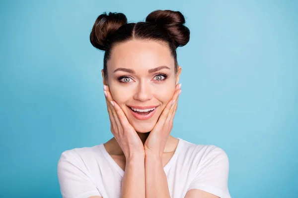 Foto de incrível senhora com penteado bonito segurando braços em maçãs do rosto usar branco casual t-shirt isolado fundo azul — Fotografia de Stock