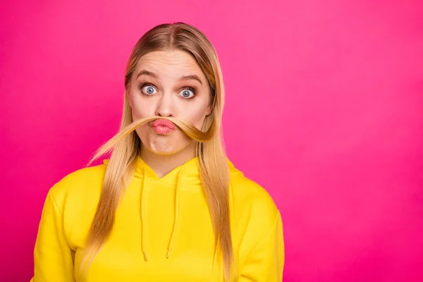 偽の口ひげを作るカールで遊ぶ狂気の女性の写真は、黄色のパーカープルオーバー孤立したピンクの背景を着用 — ストック写真