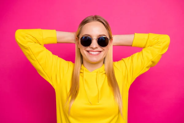 Foto di bella signora che tiene le mani dietro la testa rilassante usura sole specs giallo felpa con cappuccio isolato sfondo rosa — Foto Stock