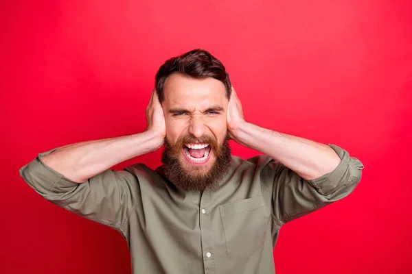 Foto de hombre molesto gritando con las orejas cubiertas irritado y molestado mientras aislado con fondo rojo — Foto de Stock