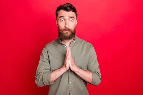 Foto de rezar esperando que o homem veja algo decepcionante enquanto isolado com fundo vermelho — Fotografia de Stock