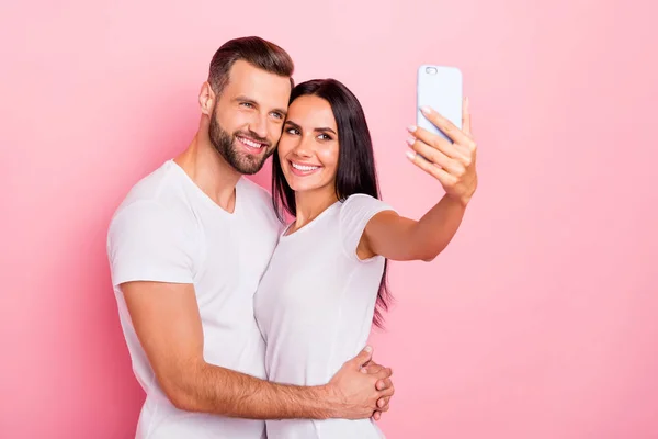 Zdjęcie pięknej pary obchodzi rocznicę i biorąc selfie razem, a izolowane z pastelowych tle — Zdjęcie stockowe