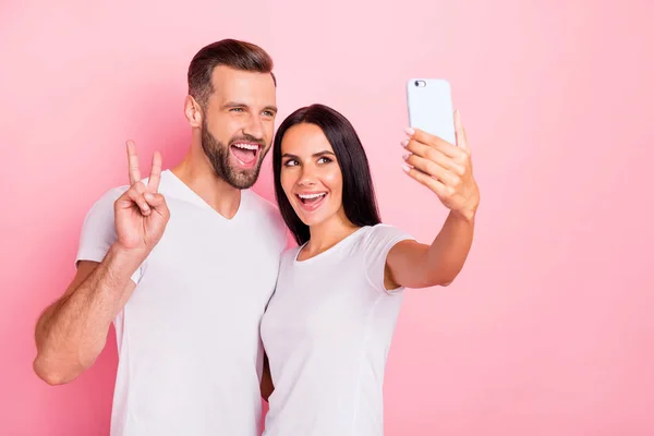 Retrato de su ella ella dos guapos atractivos encantadores encantadores alegres alegres cónyuges usando tomar haciendo selfie mostrando v-signo aislado sobre fondo pastel rosa —  Fotos de Stock