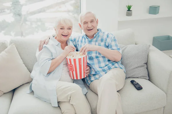 Acima da visão de alto ângulo de dois cônjuges alegres positivos alegres atraentes agradáveis que se divertem passando tempo livre assistindo cinema engraçado em série na sala de estar interior branca clara dentro de casa — Fotografia de Stock