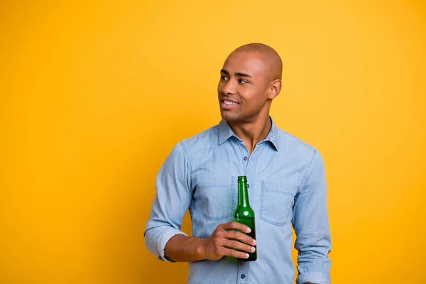 Foto de piel oscura macho levantar la mano botella de cerveza escuchar amigos sport bar usar jeans camisa de mezclilla aislado de color amarillo brillante fondo — Foto de Stock