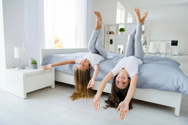 Porträt fröhlich lustige Kinder heben Beine lachen fühlen Ruhe entspannen gemütliches Schlafzimmer drinnen — Stockfoto