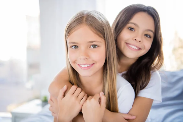 Close up foto di affascinanti bambini biondi bruna capelli hanno legame si sentono soddisfatti sedersi letto al chiuso camera hanno pigiama party — Foto Stock