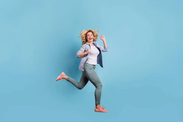 Profil na celé velikosti na boční fotografii hezké dámy se smíchem v kalhotách izoluje modré pozadí — Stock fotografie