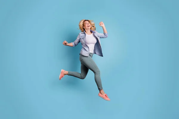 Foto de comprimento total da pessoa encantadora levantando braços rindo usando calças isoladas sobre fundo azul — Fotografia de Stock
