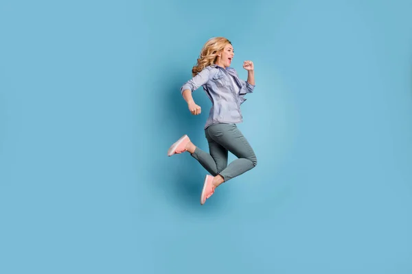 Profile side full length photo of delighted person shouting wearing pants trousers isolated over blue background