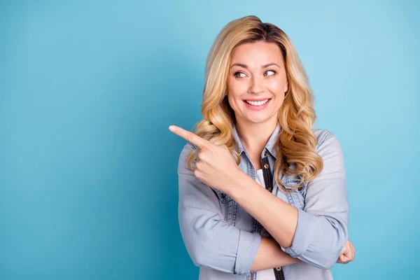 Close up photo of cheerful woman pointing at copy space showing ads isolated over blue background — Stock Photo, Image