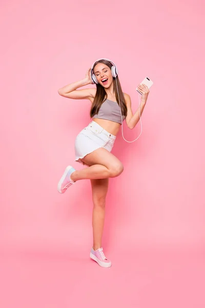 Volledige lengte foto van charmante Youngster met headset sluiten ogen schreeuwen dragen grijs Tank-Top denim jeans rok geïsoleerd over roze achtergrond — Stockfoto