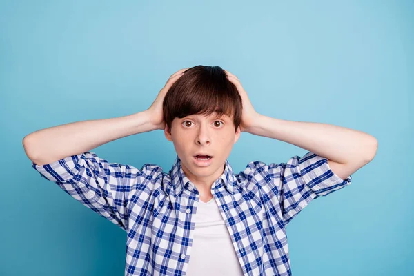 Retrato de niño horrorizado impresionado tocándose la cabeza con las manos usando camisa a cuadros aislada sobre fondo azul —  Fotos de Stock