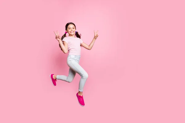 Foto lateral de longitud completa de la hermosa señorita saltando alto símbolo v-signo vestido traje casual aislado fondo rosa —  Fotos de Stock