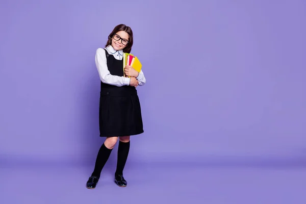 Longitud completa tamaño del cuerpo vista de agradable atractivo alegre inteligente de pelo ondulado pre-adolescente chica lista para la clase sosteniendo en las manos literatura académica aislado sobre brillante brillante brillo violeta fondo —  Fotos de Stock