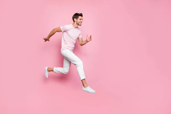 Full size profile side photo of attractive person running smiling isolated over pink background