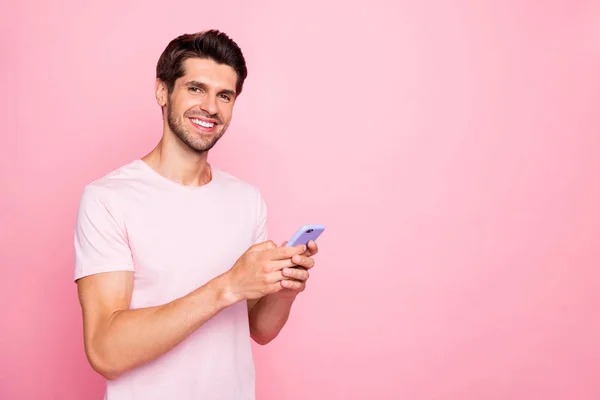 Retrato de sua agradável atraente adorável alegre confiante conteúdo cara segurando em mãos dispositivo usando namoro serviço de bate-papo isolado sobre fundo pastel rosa — Fotografia de Stock