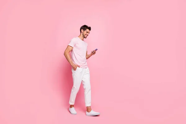 Lunghezza intera dimensione del corpo vista ritratto del suo bel contenuto attraente allegro ragazzo allegro a piedi godendo di tempo libero isolato su sfondo rosa pastello — Foto Stock