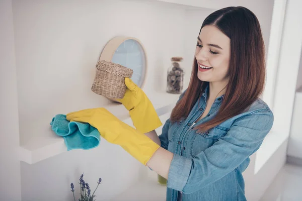 Foto de empregada doméstica bonita fazer limpeza geral primavera empoeirado prateleira de móveis brancos sala de estar — Fotografia de Stock