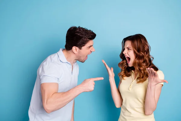 Foto de irritado selvagem gritando par sua culpa expressão negativa desgaste casual t-shirts isolado fundo azul — Fotografia de Stock