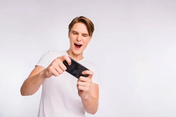 Foto de un tipo increíble sosteniendo las manos del teléfono jugar emocionante juego desgaste traje casual aislado sobre fondo blanco —  Fotos de Stock