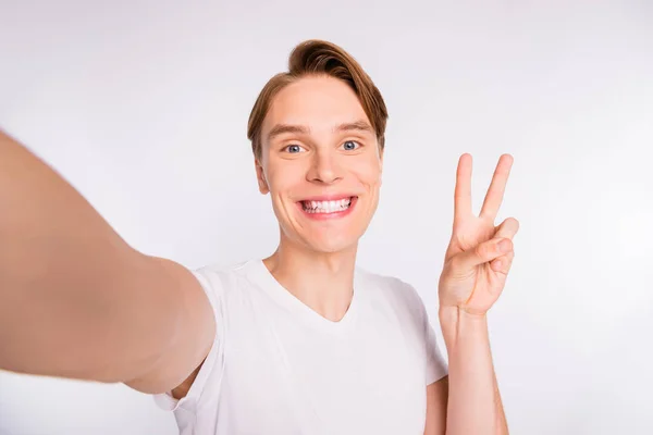 Close up foto di studente ragazzo fare selfie mostrando v-segno simbolo indossare abbigliamento casual isolato sfondo bianco — Foto Stock