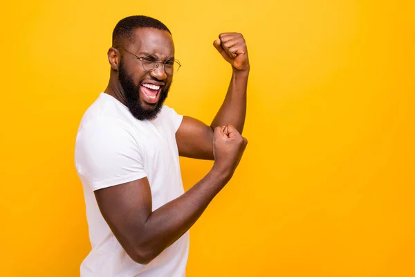 stock image Dark skin guy celebrating lottery winning raising fist up wear casual outfit isolated yellow background