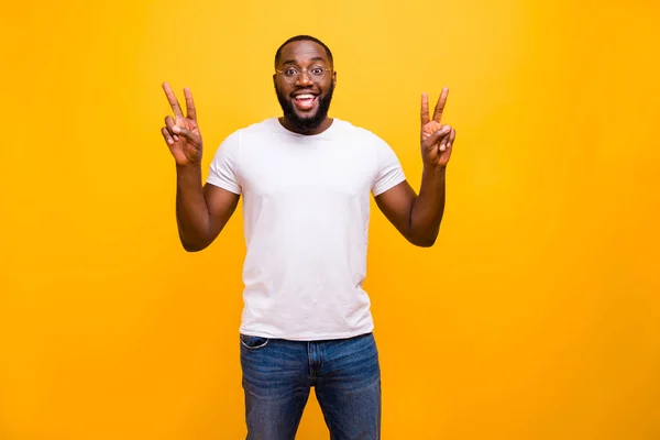 Foto van vrolijke leuke aardige vriendelijke Afrikaanse man toont v-teken op zoek naar vrienden in nieuwe stad hij is nog nooit eerder geweest, terwijl geïsoleerd met levendige achtergrond — Stockfoto