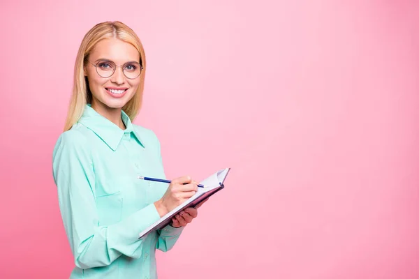 Turned photo of charming manager holding copy book looking with toothy smile wearing eyeglasses eyewear isolated over pink background — Stock Photo, Image
