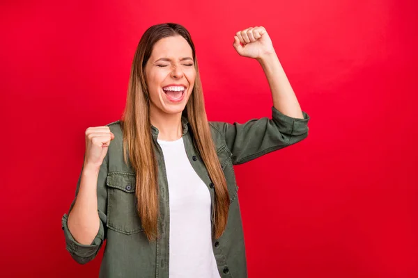 Foto van dolblij succesvolle mooie gestreefd vrouw viert haar overwinning terwijl geïsoleerd met rode achtergrond — Stockfoto