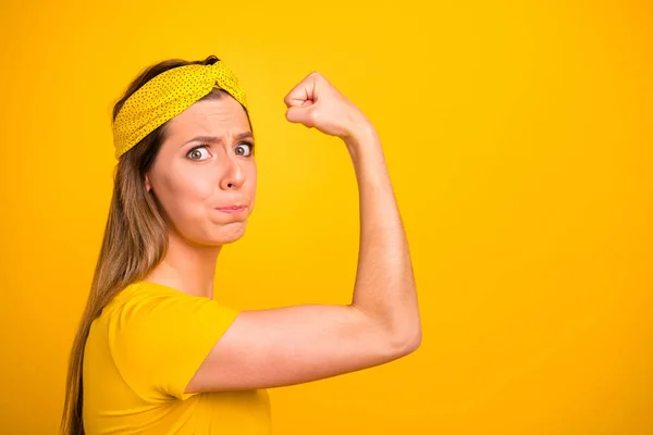 Closeup photo of beautiful lady trying hard to make hand muscle bigger wear casual t-shirt isolated yellow background — Stock Photo, Image