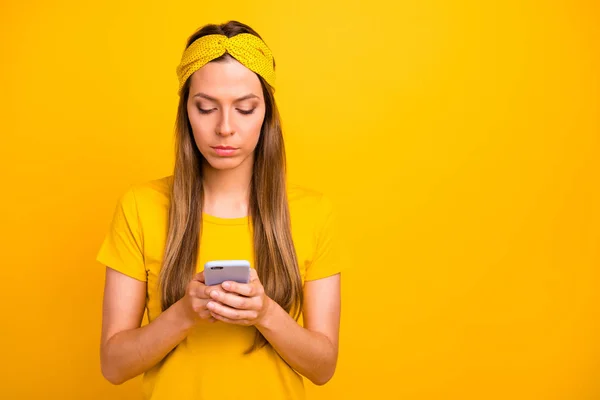 Крупный план фото красивой леди, держащей в руках телефон носить повседневную футболку изолированный желтый фон — стоковое фото
