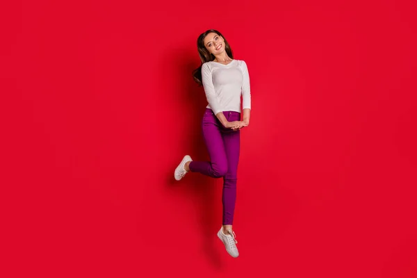 赤い背景で孤立しながら何かを賞賛するジャンプ恥ずかしがり屋かわいい魅力的な女性のフルレングスボディサイズの写真 — ストック写真