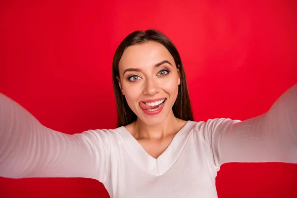Photo of cute nice girl pretending to be sexy licking her upper lip while isolated with red background