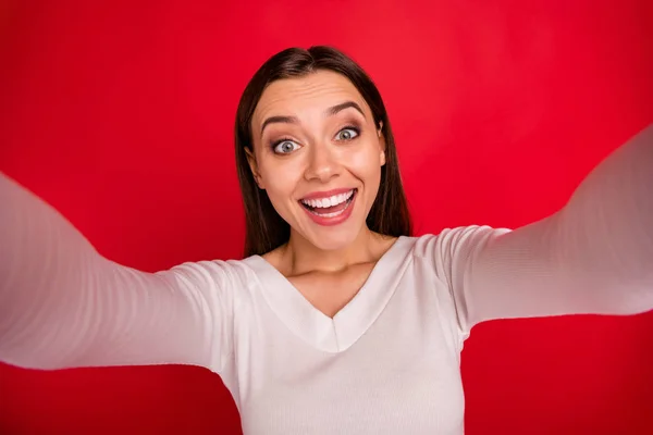 Photo of rejoicing woman having been given new camera just to hold it in hands but she started playing it while isolated with red background — Stock Photo, Image