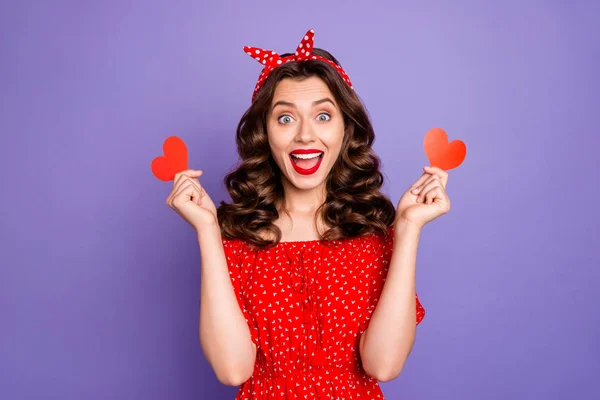 Mooie dame houden kleine hart figuur kaarten in armen dragen rode jurk geïsoleerd paarse achtergrond — Stockfoto