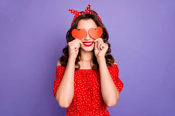 Senhora bonita no humor brincalhão escondendo os olhos com pouco coração figura cartões desgaste vestido vermelho isolado roxo fundo — Fotografia de Stock